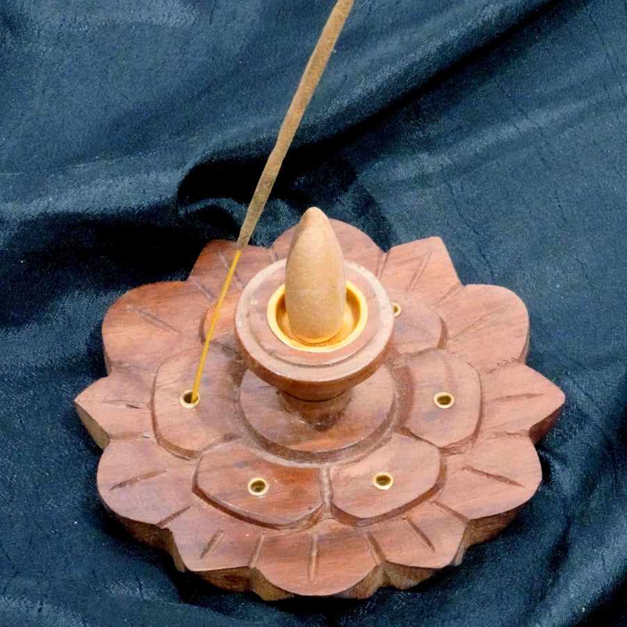 Wooden incense burner with a cone on a blue fabric background