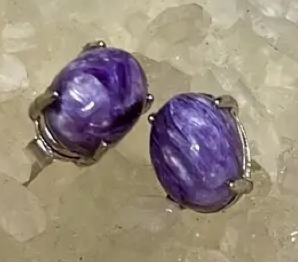 Purple stone earrings on a textured surface