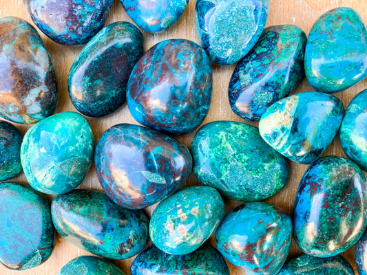 Blue and green tumbled roundish stones with black and brown lines in the stones