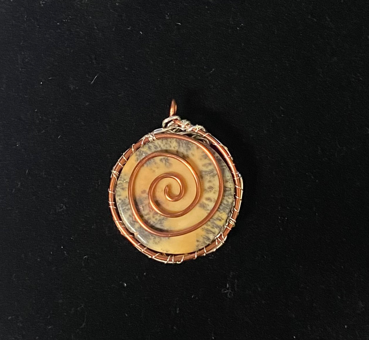 Pendant Copper Spiral Wrapped on a black background