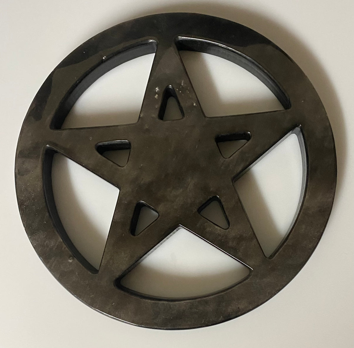 A circular sheen obsidian pentacle wall decor piece with a textured, rustic finish, shown against a plain off-white background.
