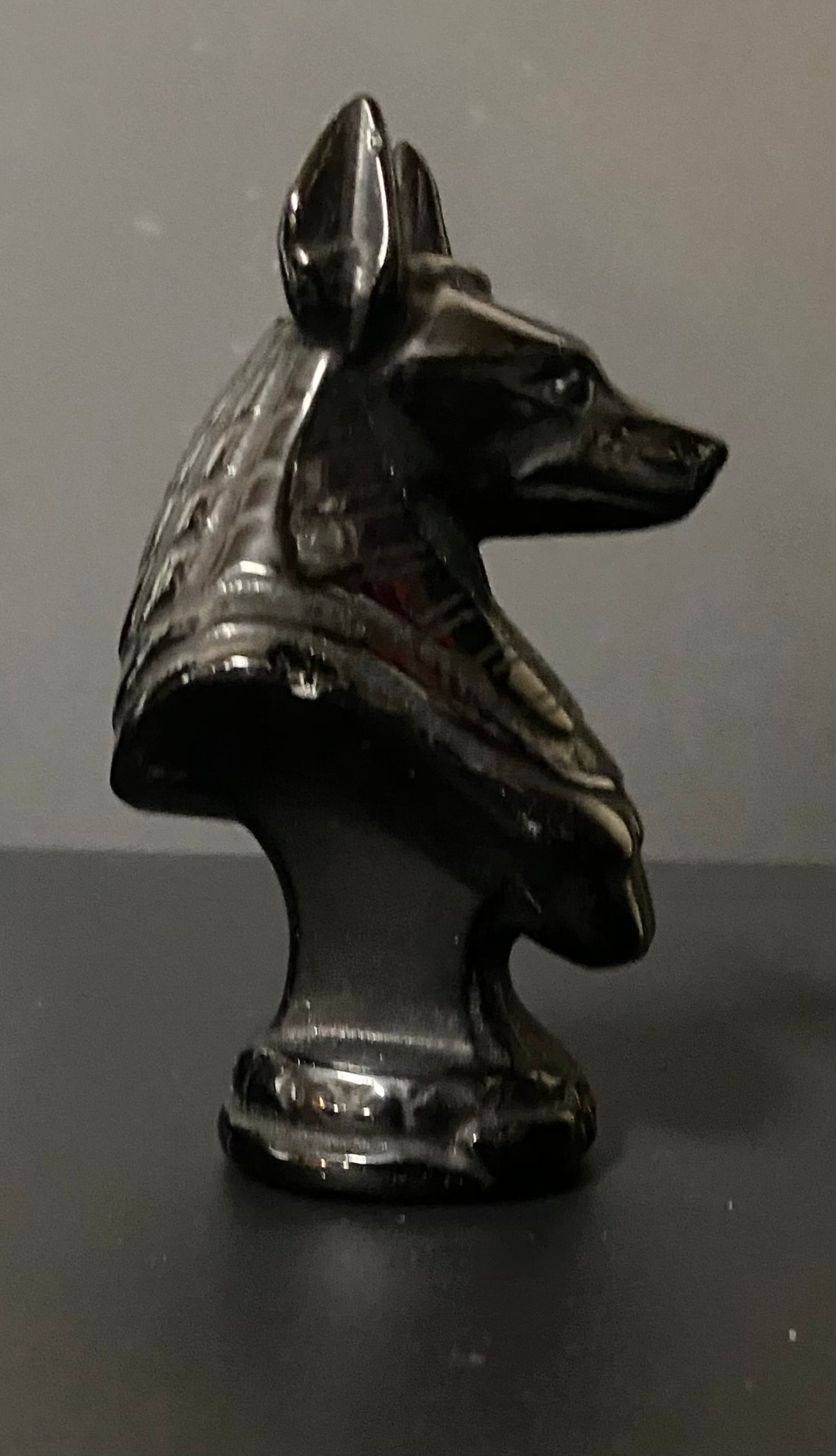 Obsidian Anubis Bust on a black background. side view