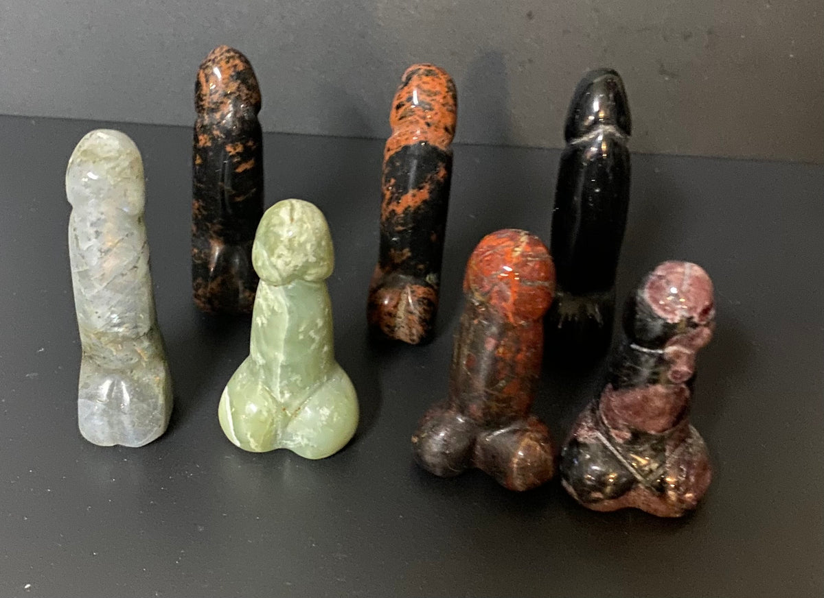 assorted stone penises carved on a black background