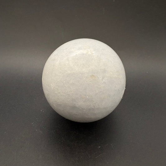 white crackled calcite sphere on gray background