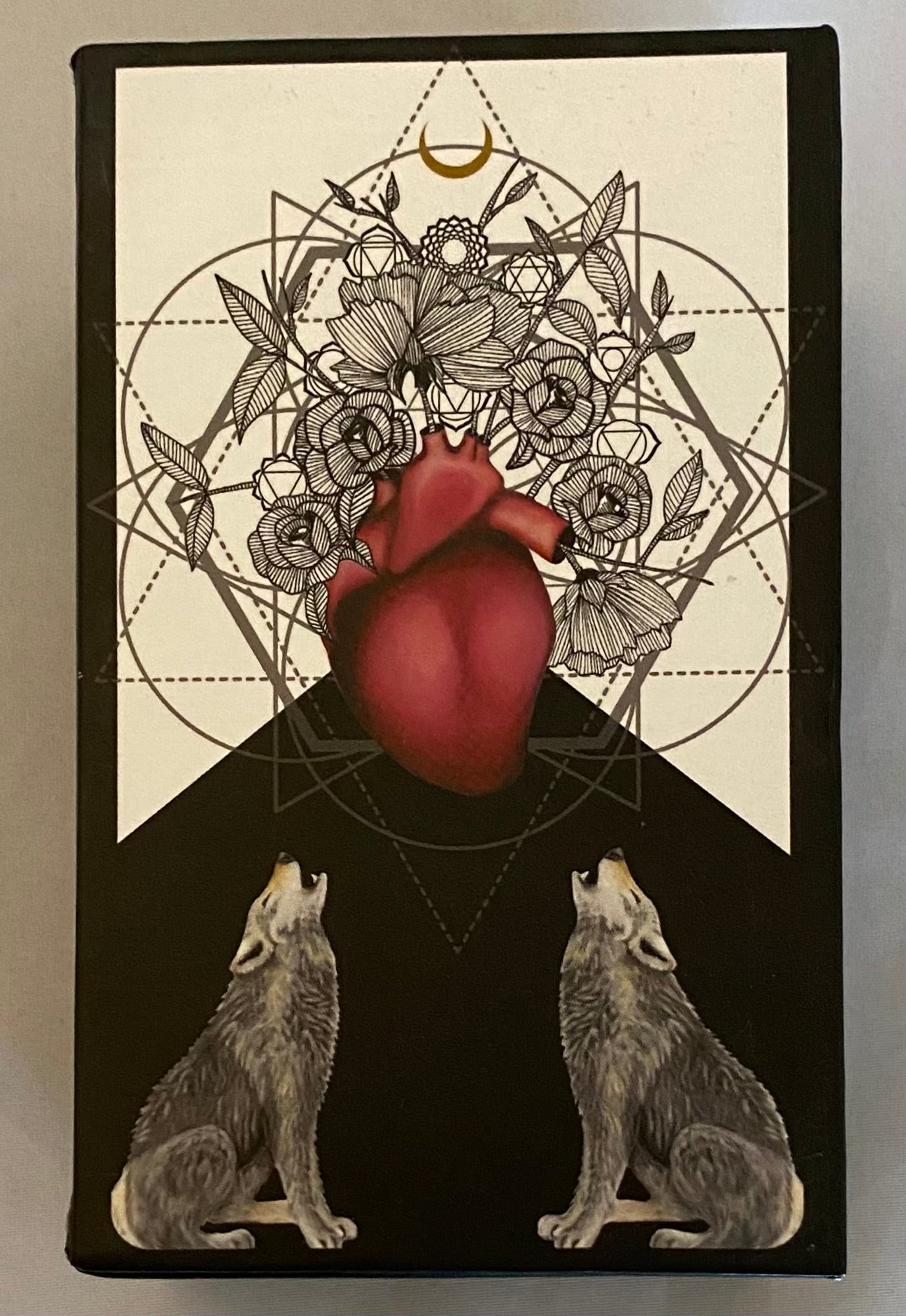 Artistic design with a heart, wolves, and floral elements on a black background