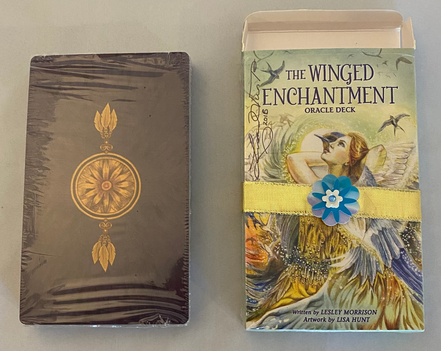 Two books or card decks with decorative covers on a plain background