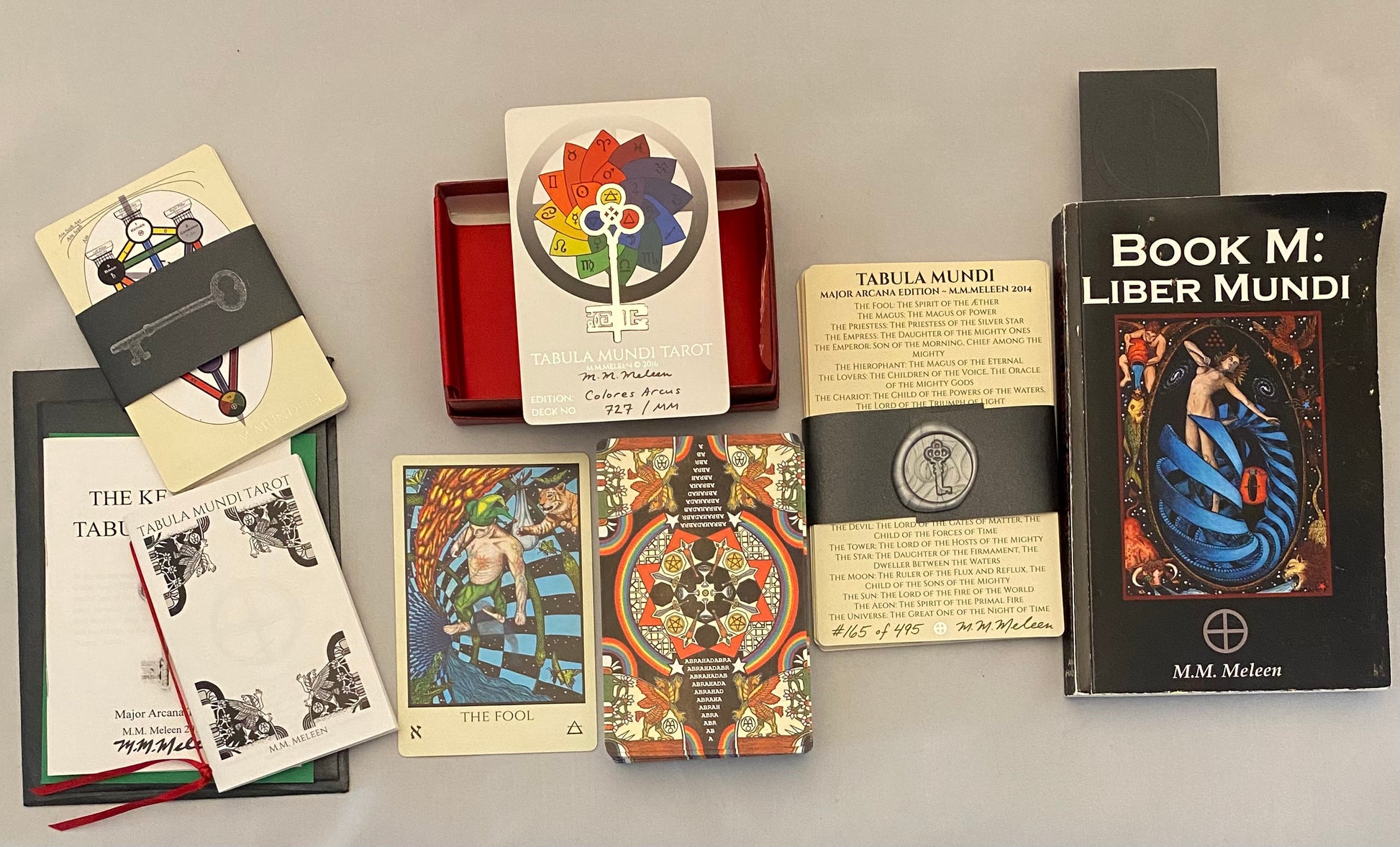 Collection of books and card decks with decorative covers on a gray surface