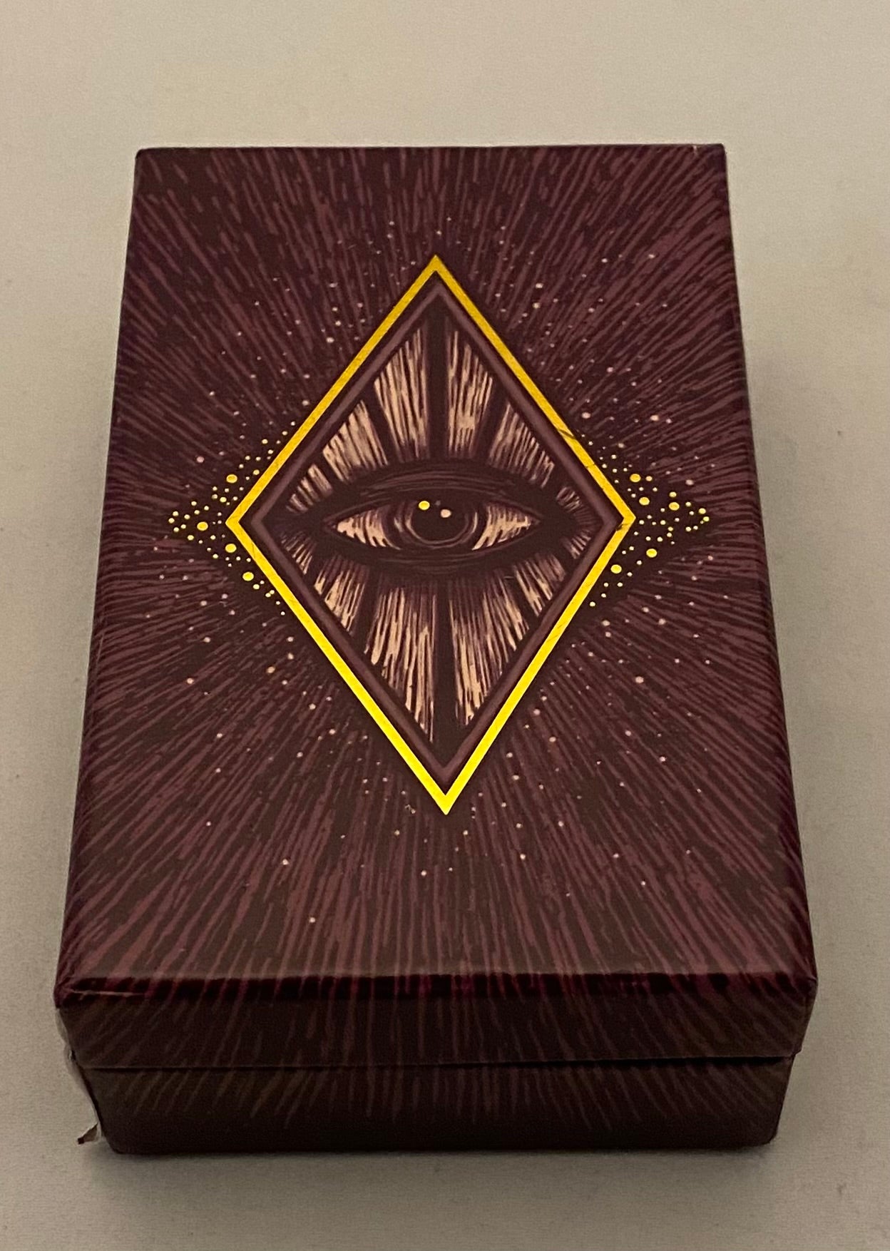 Decorative tarot box with eye design on a plain background