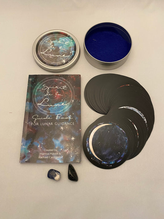 Set of tarot cards with a book titled 'The Book of Lunar Guidance' on a beige surface.