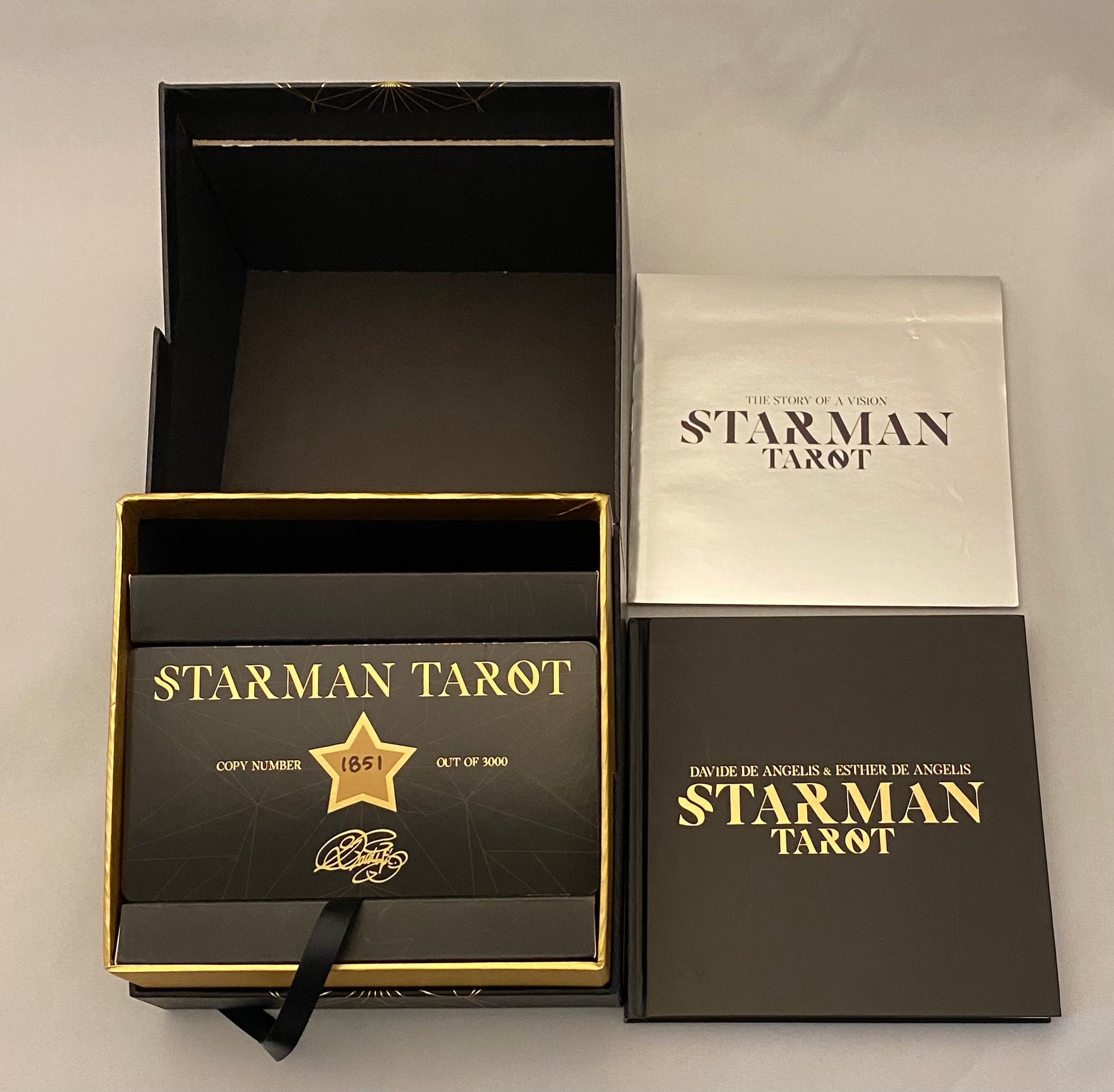 Starman Tarot set with black and gold packaging on a light gray background