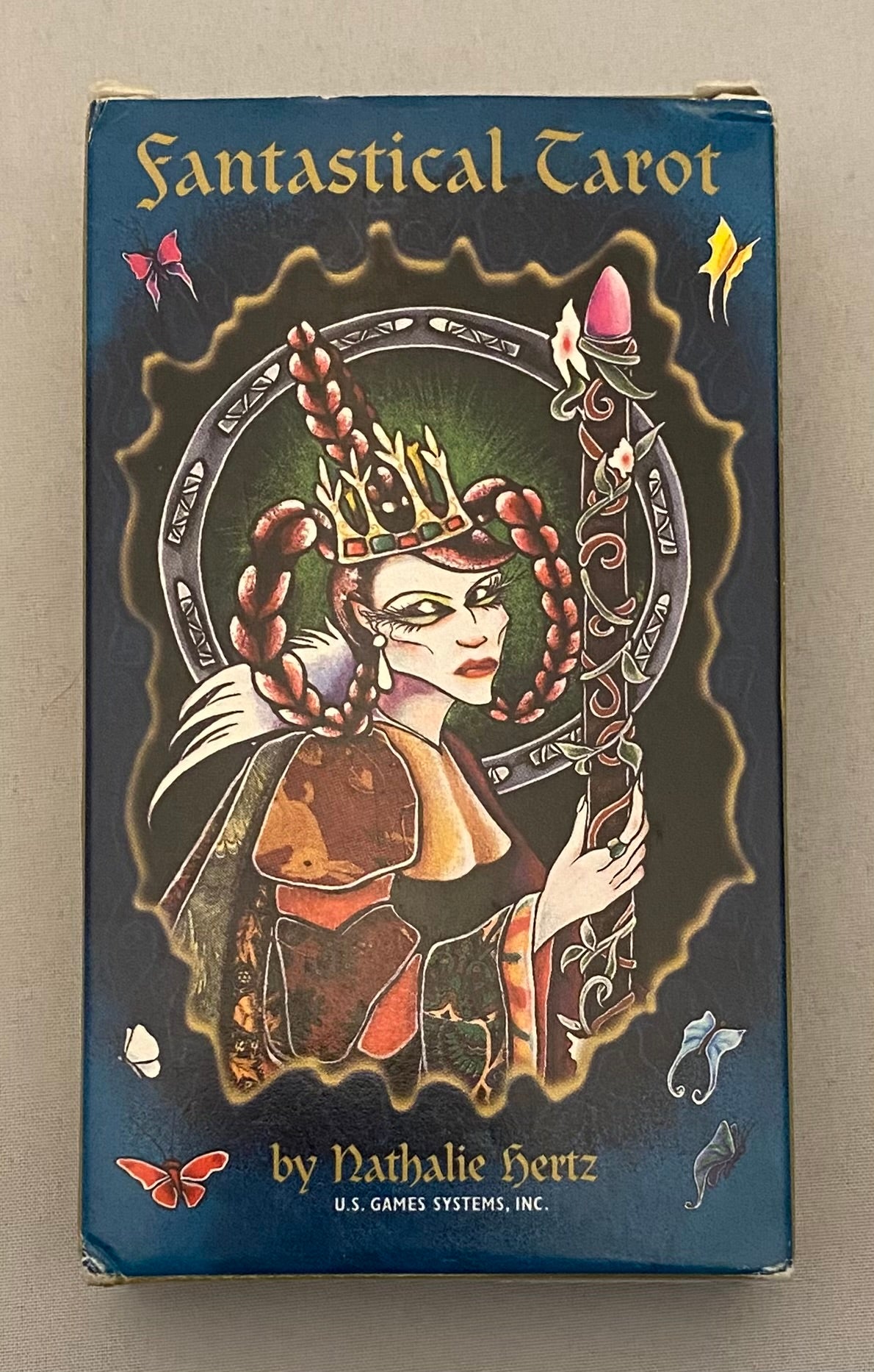 Fantastical Tarot card box with a stylized illustration of a woman with a crown and wreath on a dark background.