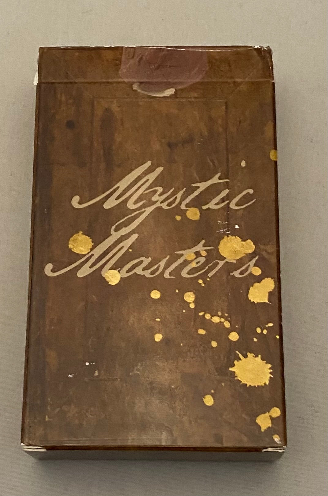 Brown box with 'Mystic Masters' text and gold accents on a gray background