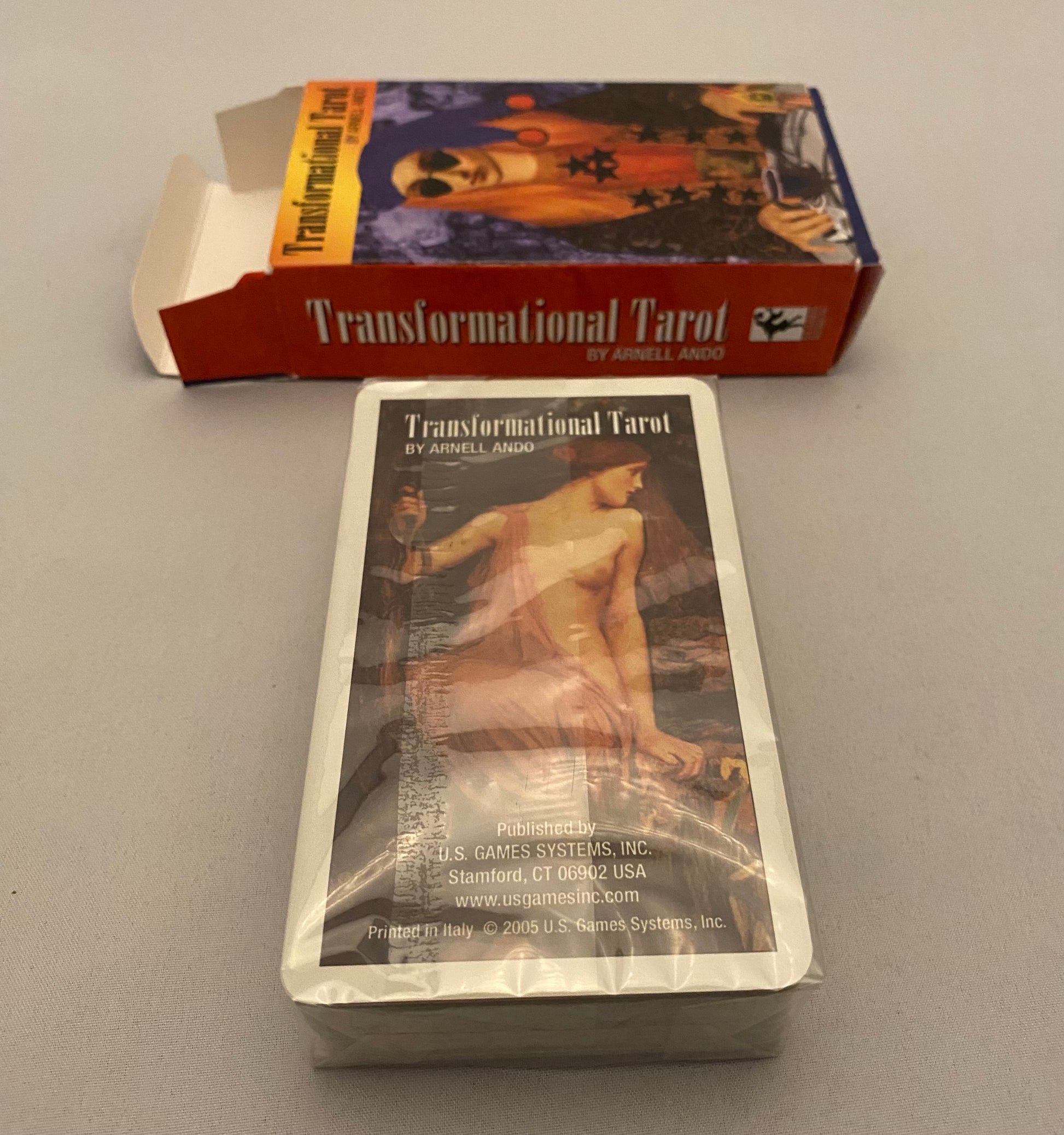 Transformational Tarot cards with packaging on a gray surface