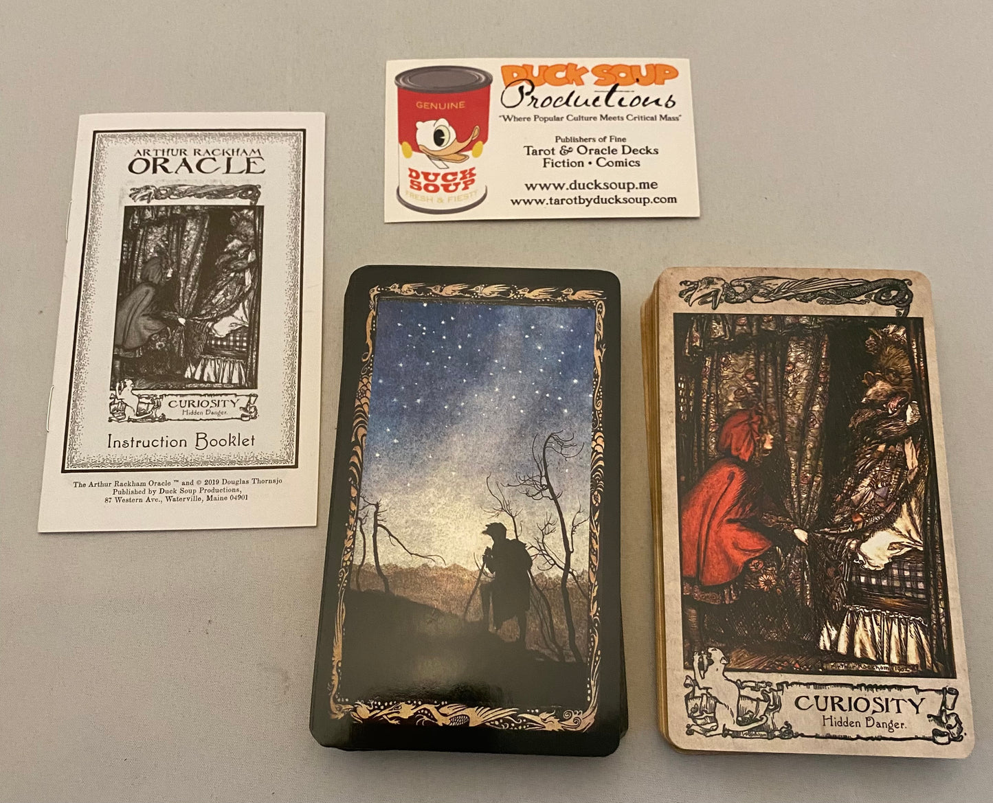 Collection of tarot cards and a business card on a gray surface