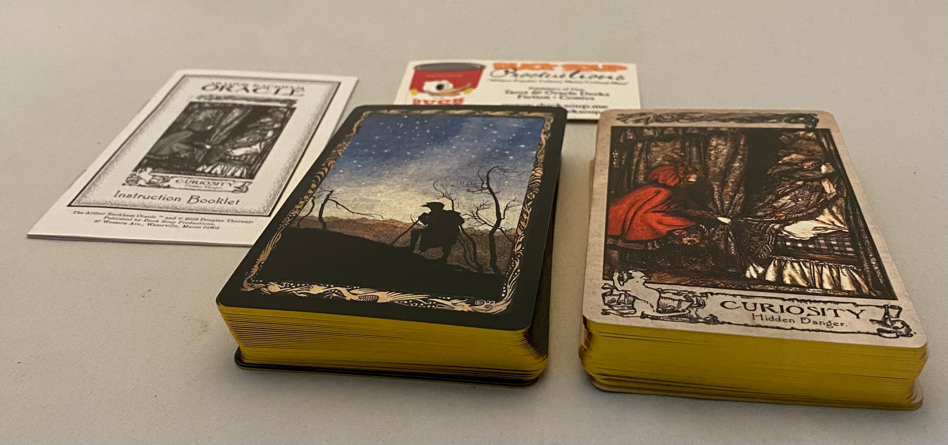 Two decks of cards with tarot card designs on a gray surface