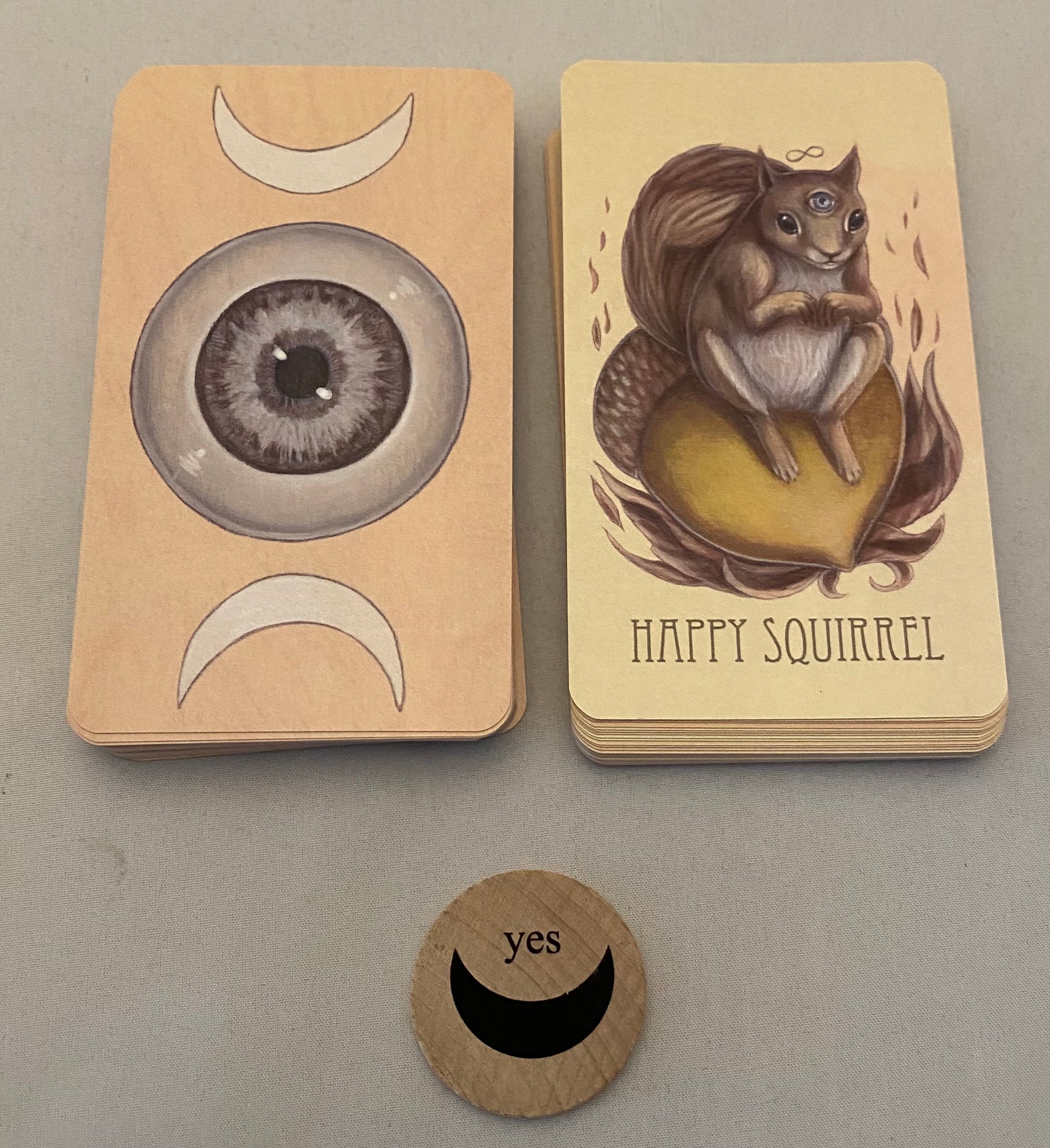 Two cards with a eye design and 'Happy Squirrel' illustration, accompanied by a circular 'yes' token.