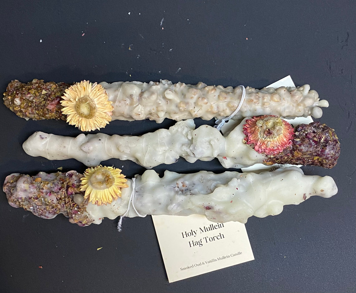 Mullein Candle with yellow flowers and rocks on a dark surface with 'Lit Rituals' labels.