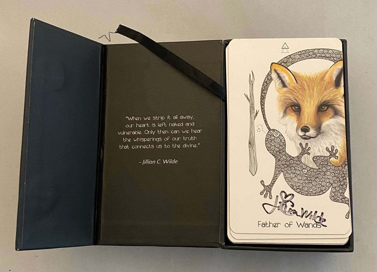 Open tarot box with a card featuring a fox and lizard illustration on a gray background