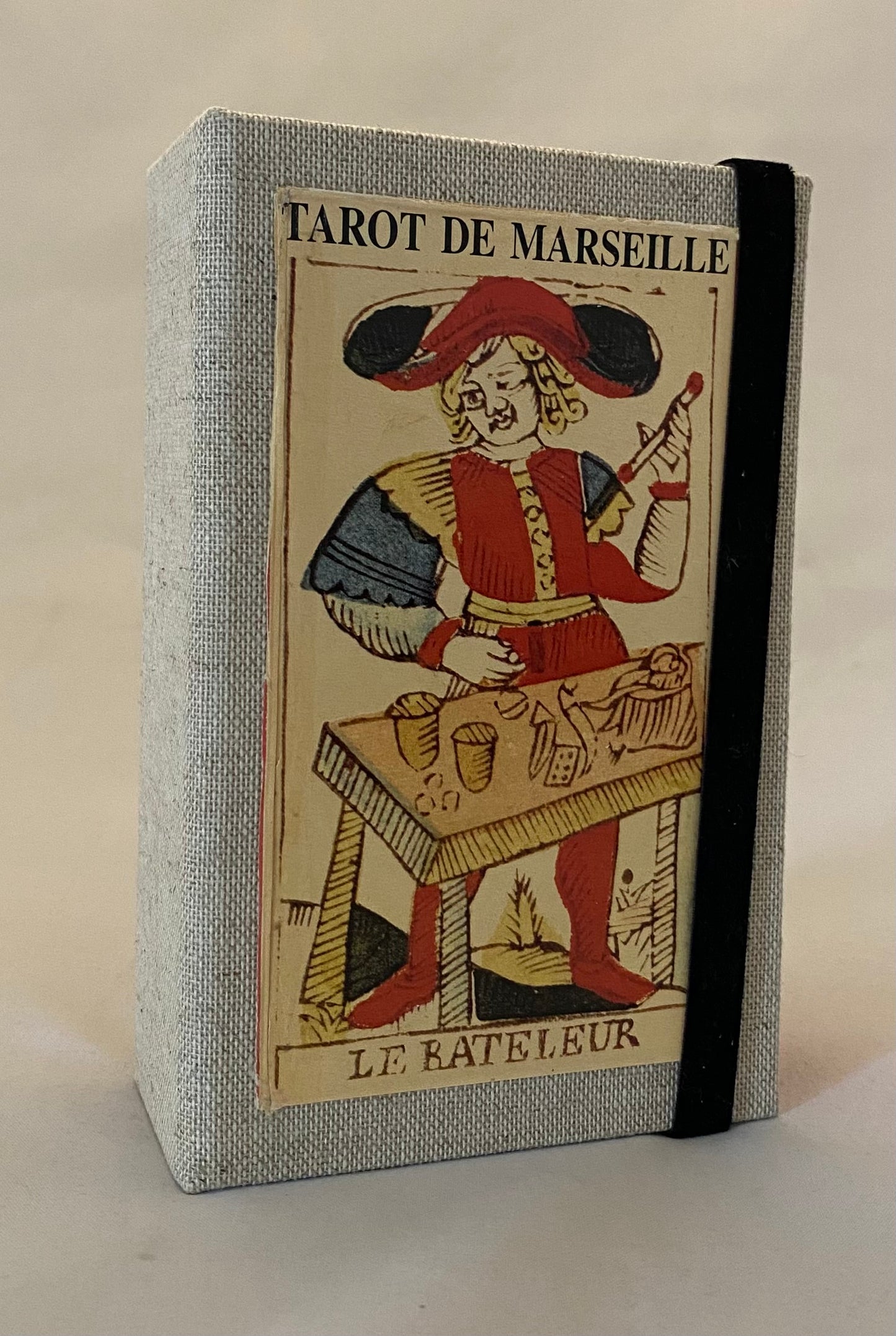 Tarot de Marseille design on the cover, featuring a character in a red hat and coat.