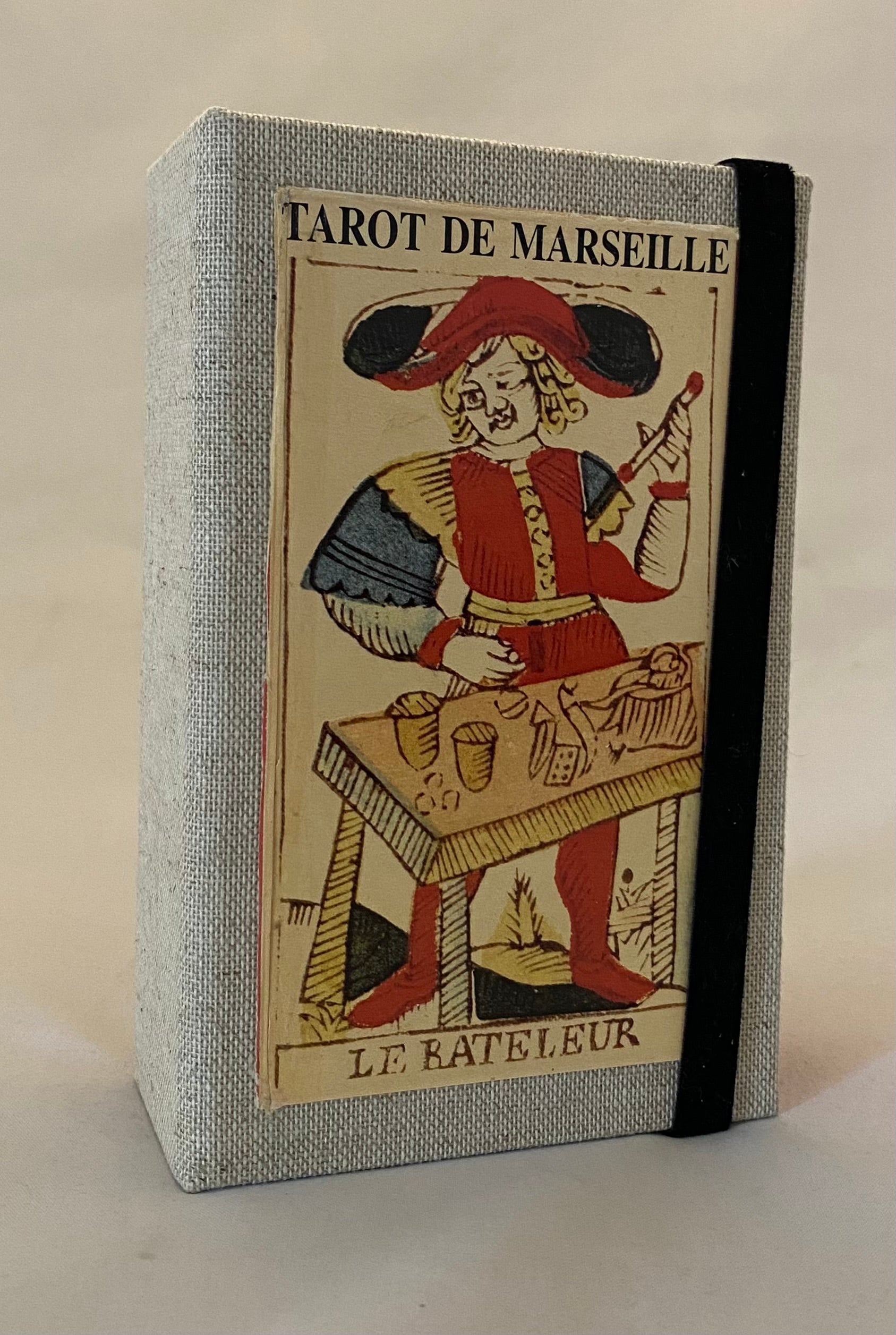 Tarot de Marseille design on the cover, featuring a character in a red hat and coat.