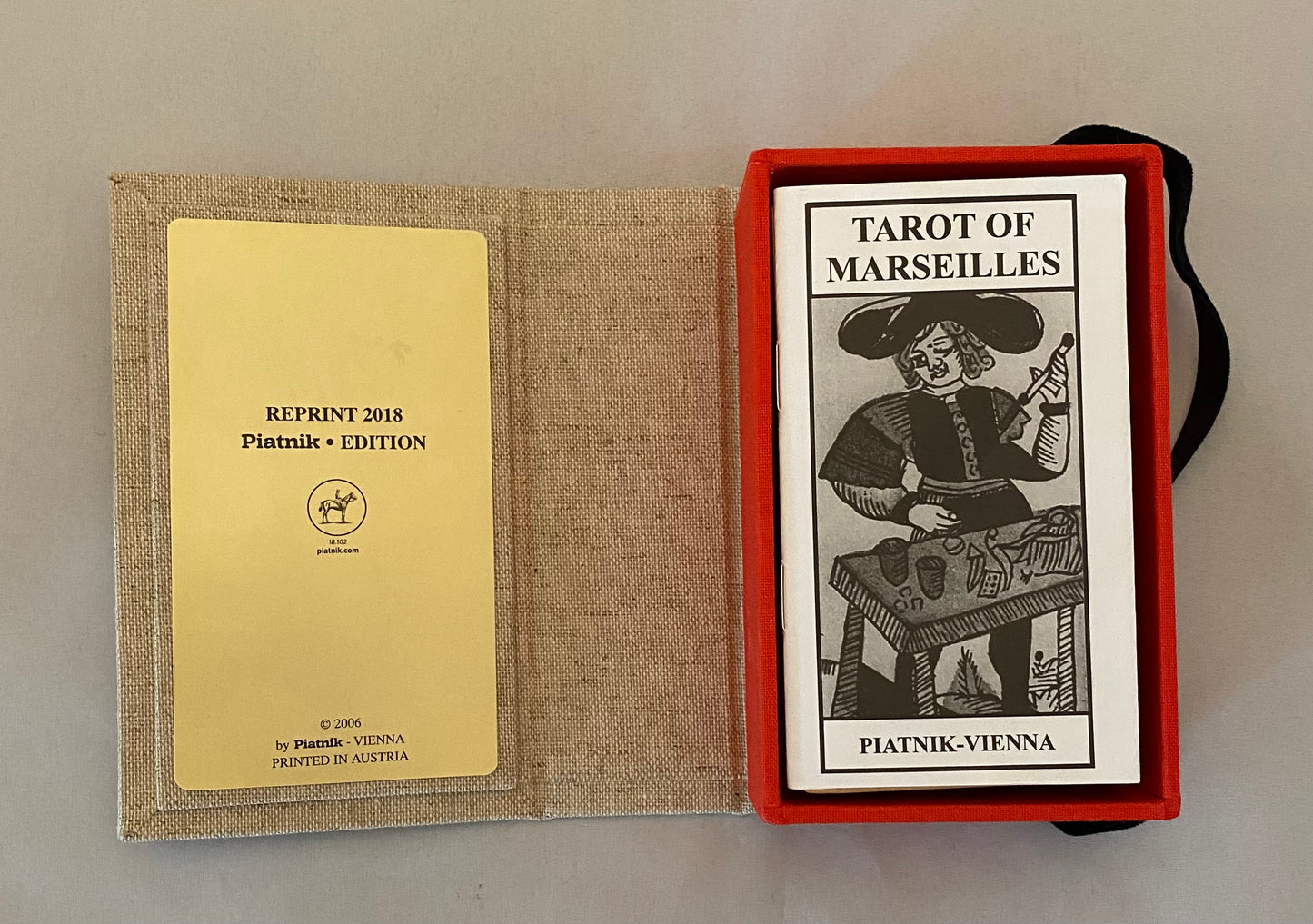 Tarot of Marseilles deck with red border and black and white illustration, accompanied by a yellow card.