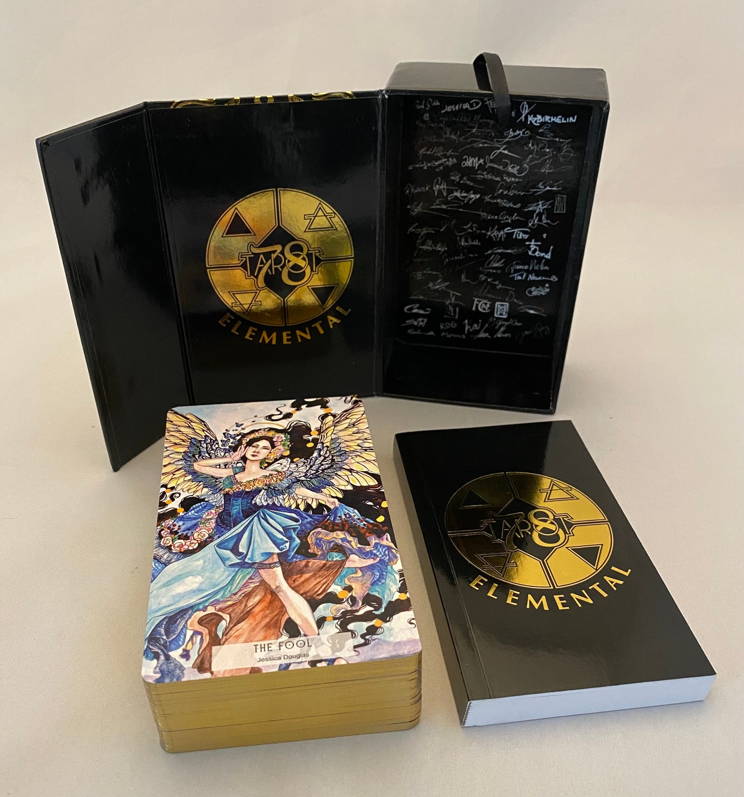 Elemental tarot cards with black and gold packaging on a white background
