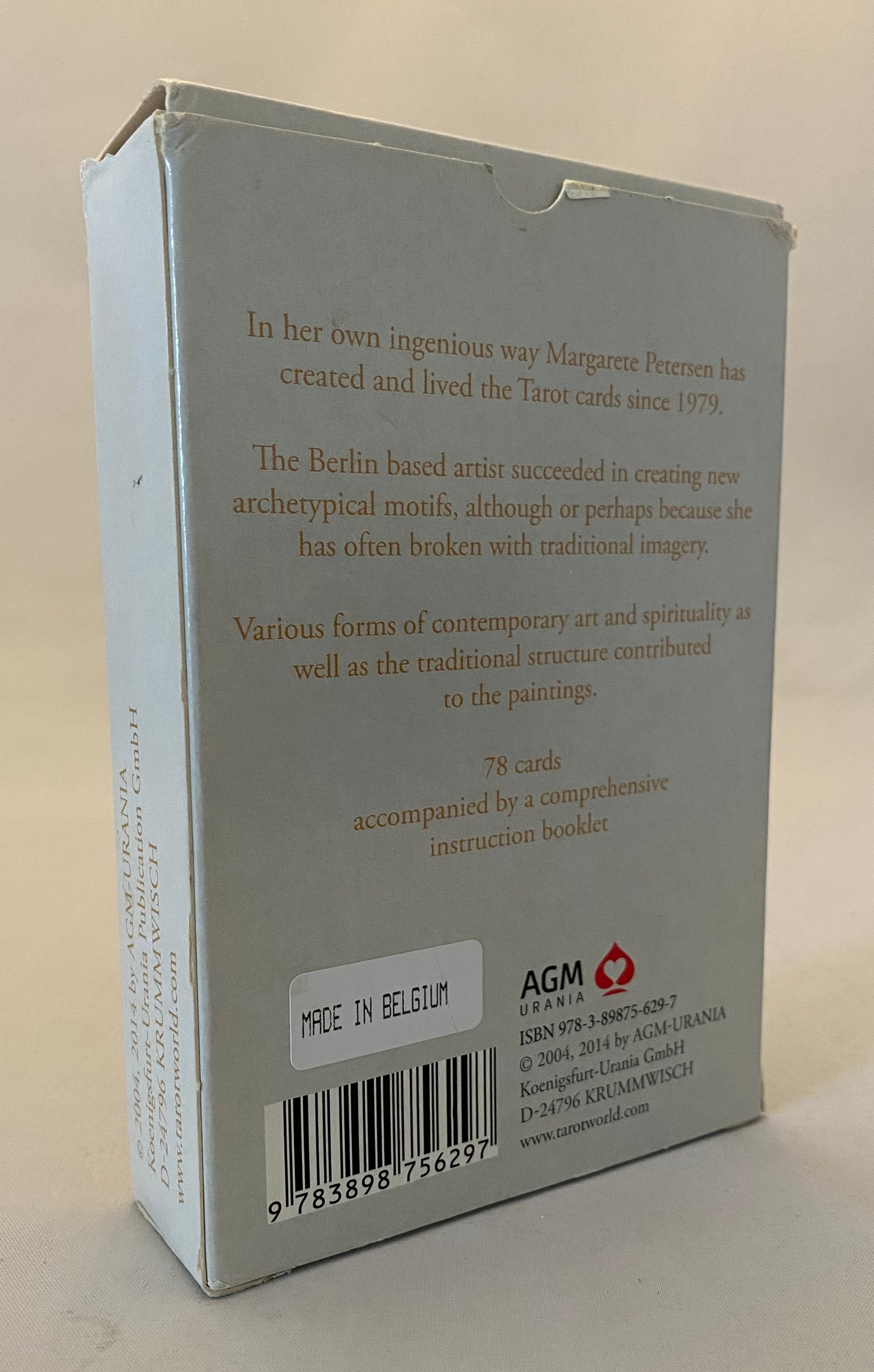 Back of a card packaging with text and AGM logo on a beige background