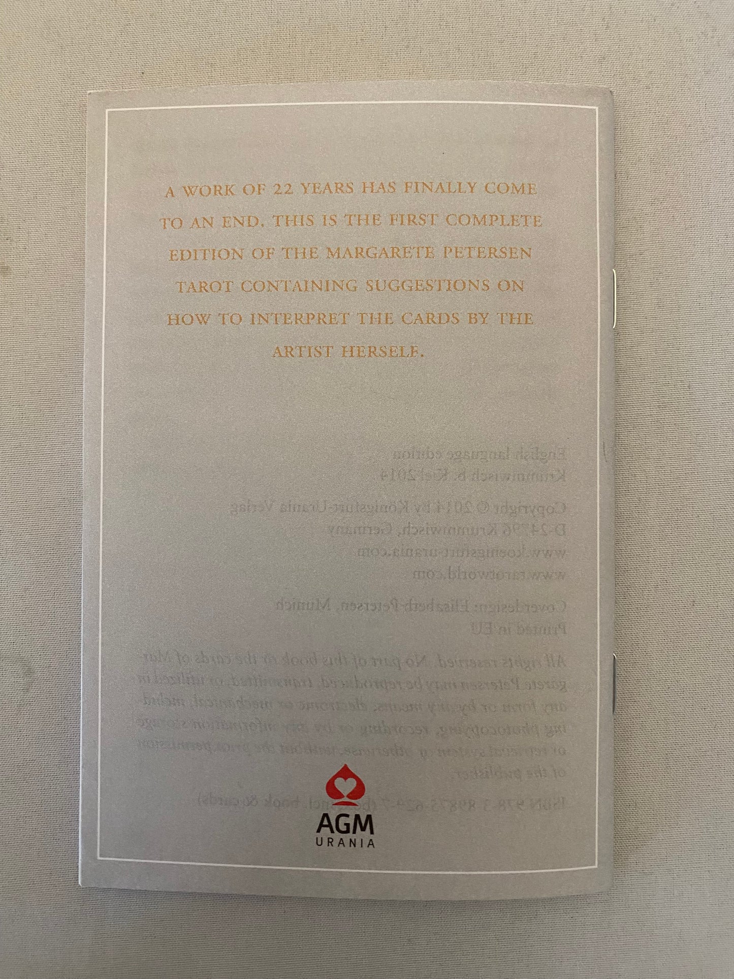 Back of guidebook with text and AGM logo on a beige background