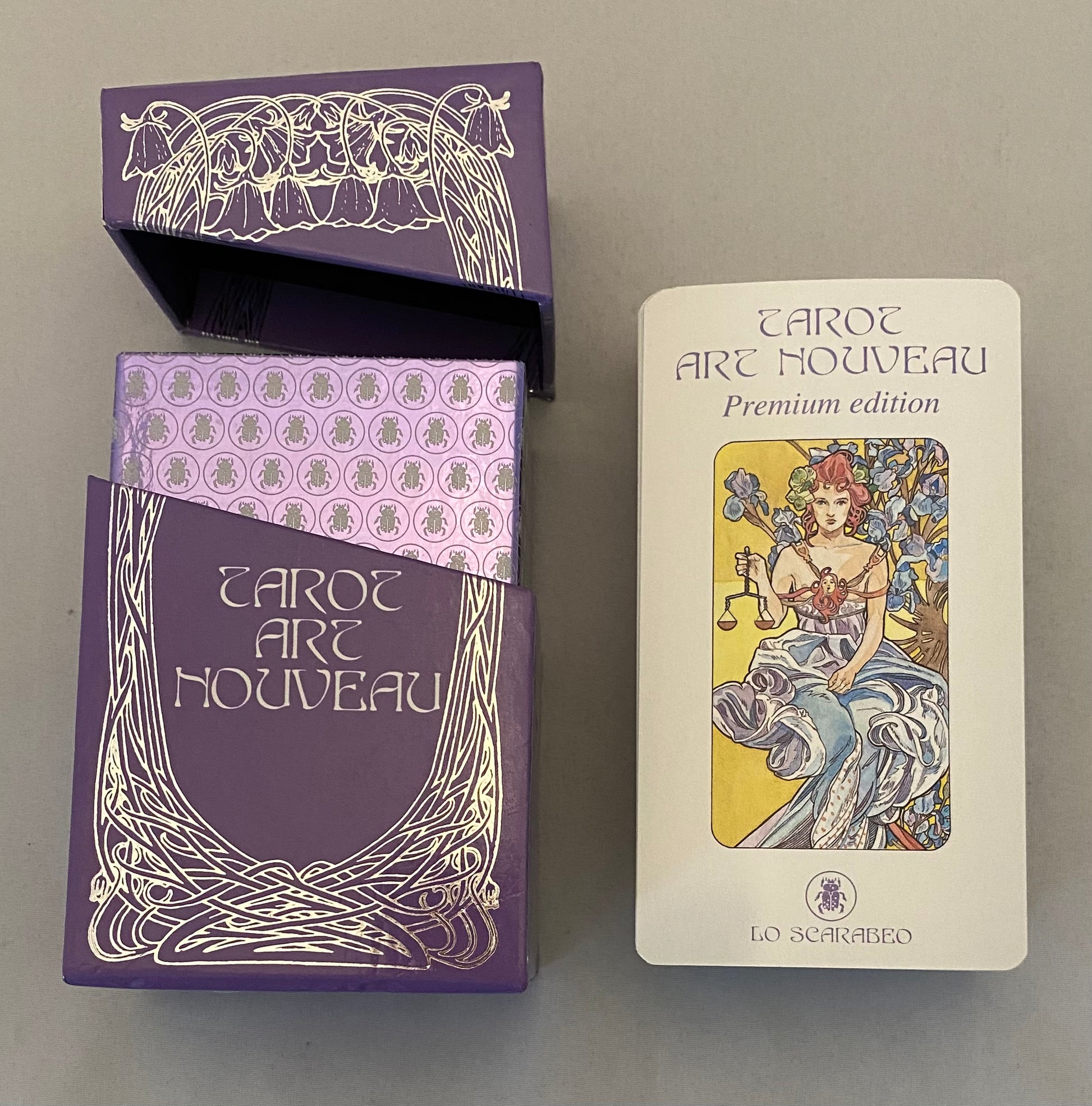 Tarot Art Nouveau tarot box with a card showing a woman and text on a gray background