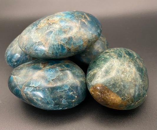 Apatite palm stones on a gray background