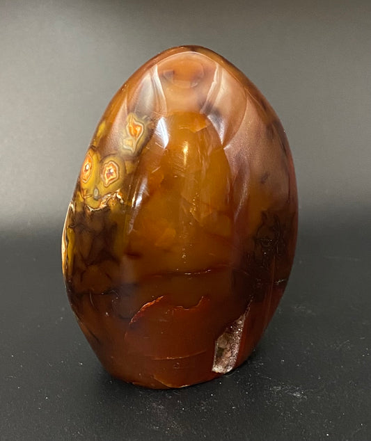 Polished carnelian stone on a dark background