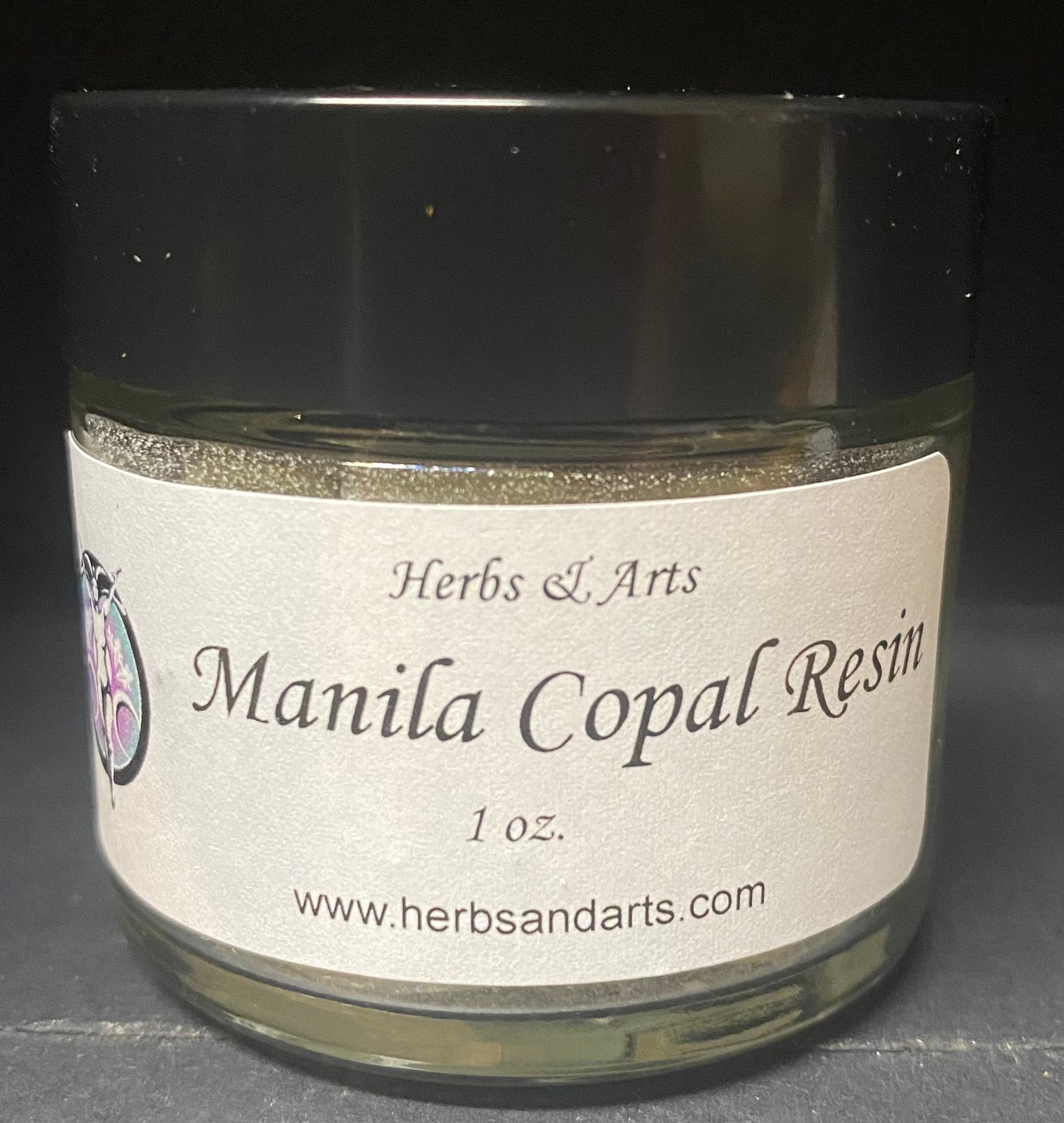 Jar of Manila Copal Resin with label on a dark background