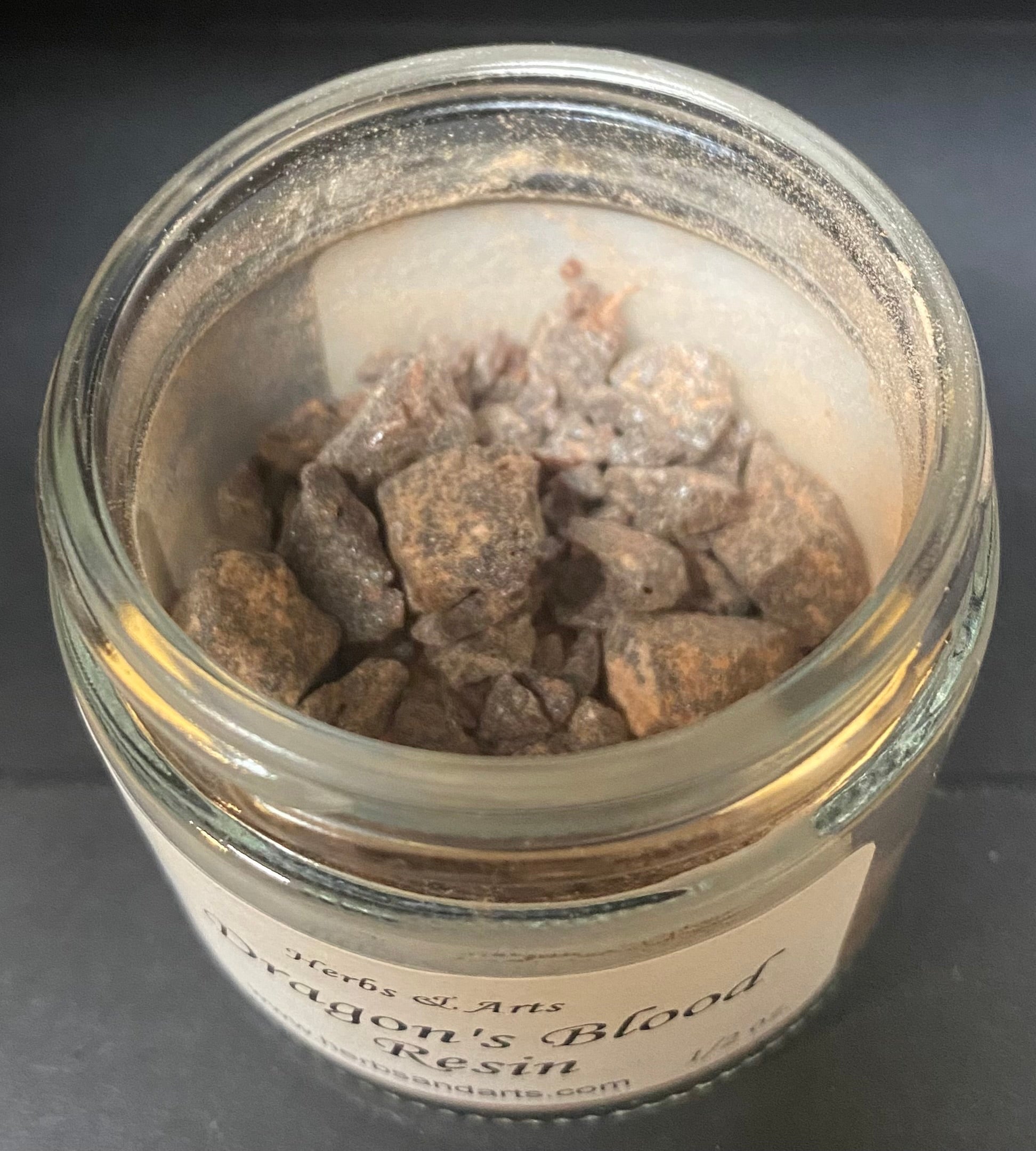Jar of Dragon's Blood resin with a label on a dark background