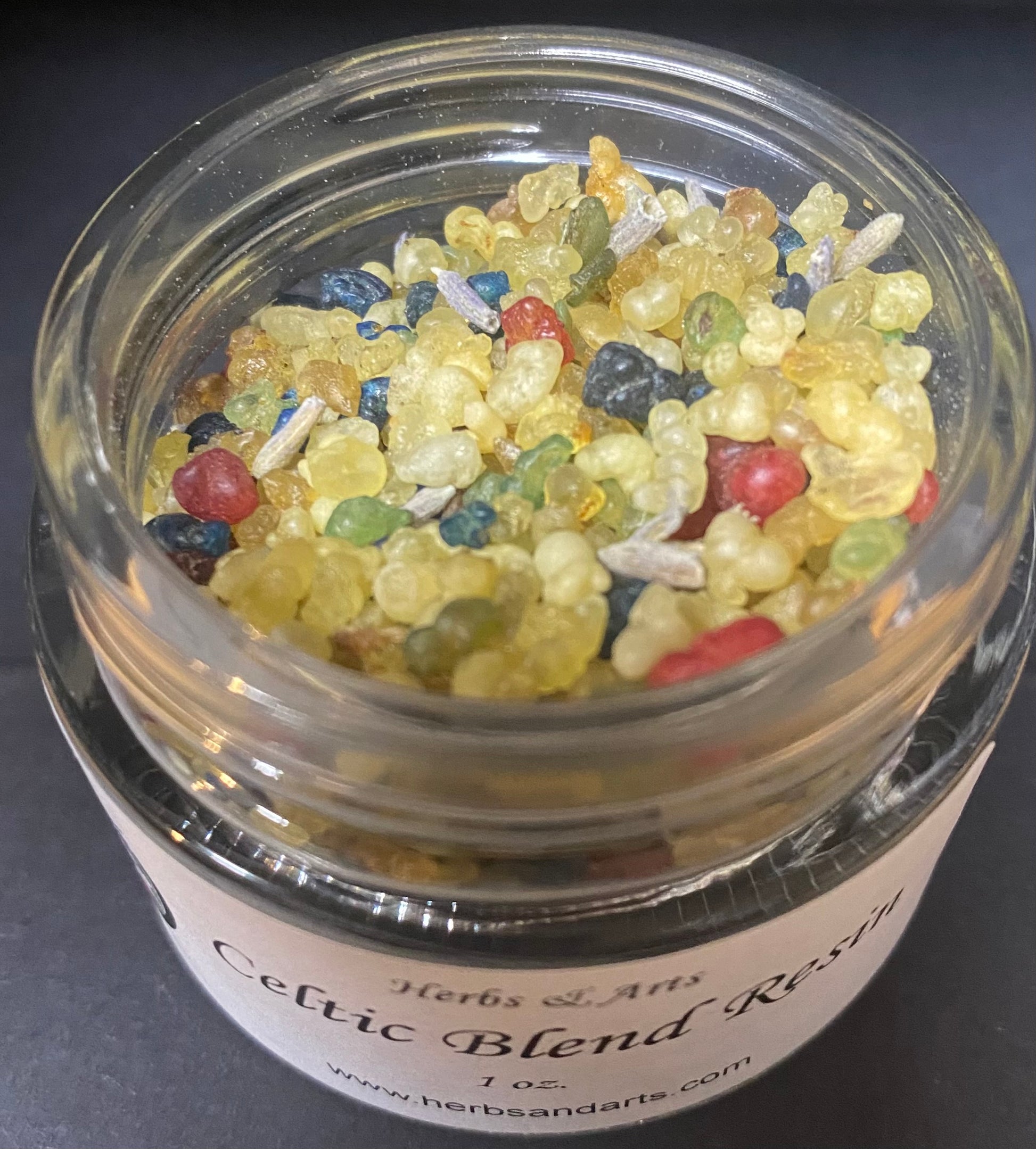 Jar of Celtic Blend Resin with colorful beads on a dark background