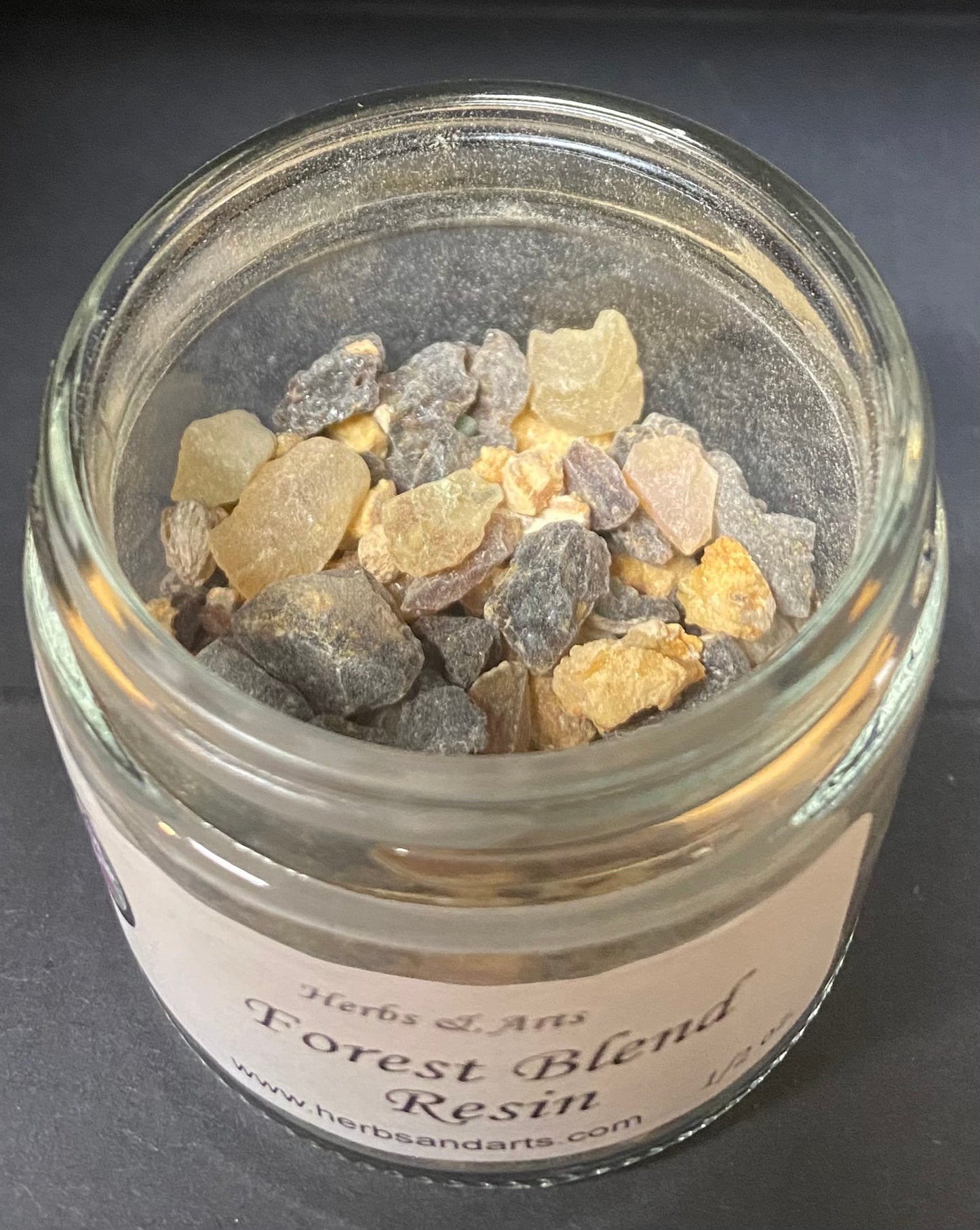 Jar of forest blend resin with a label on a dark background