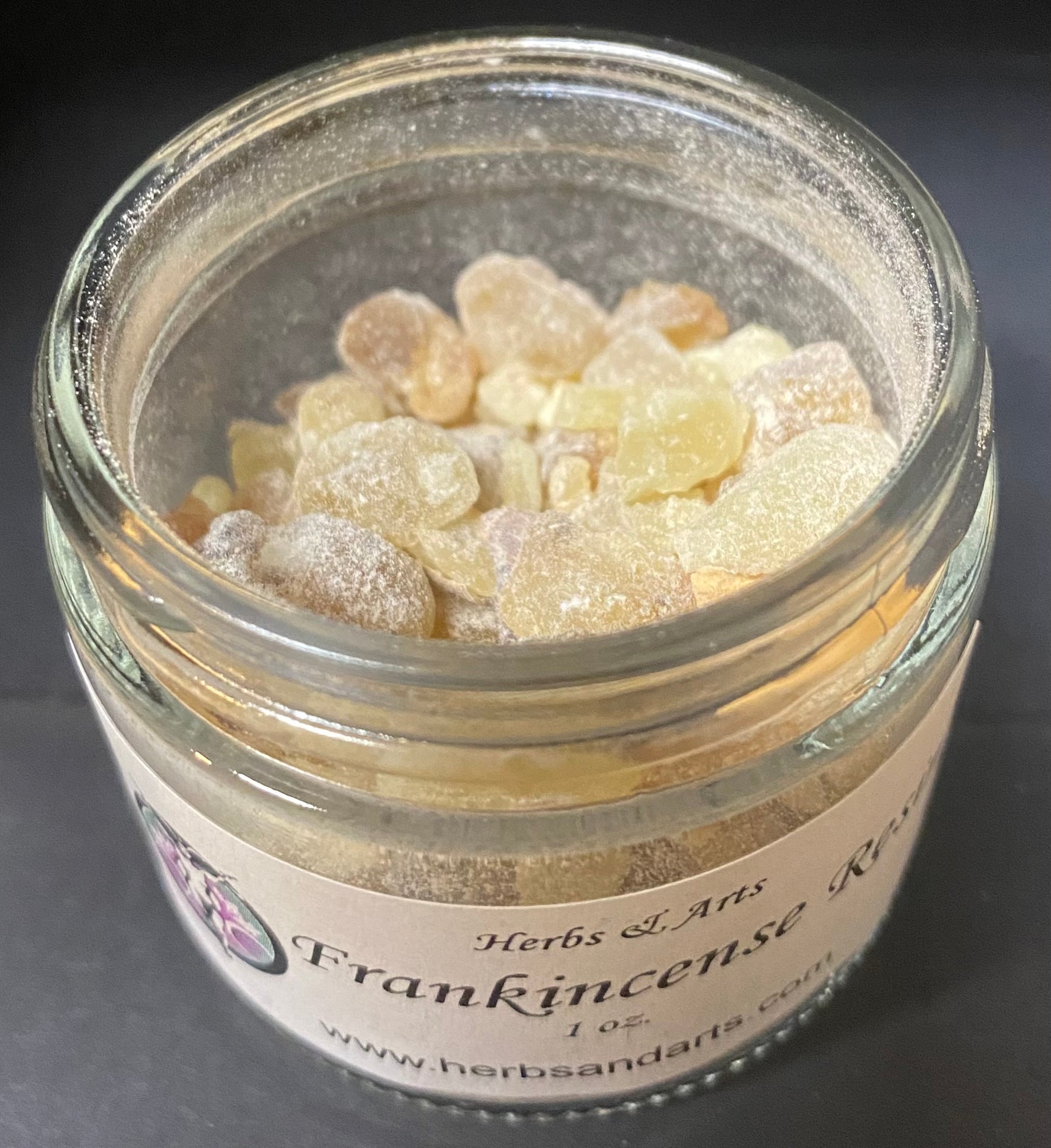 Jar of frankincense resin with a label on a dark background