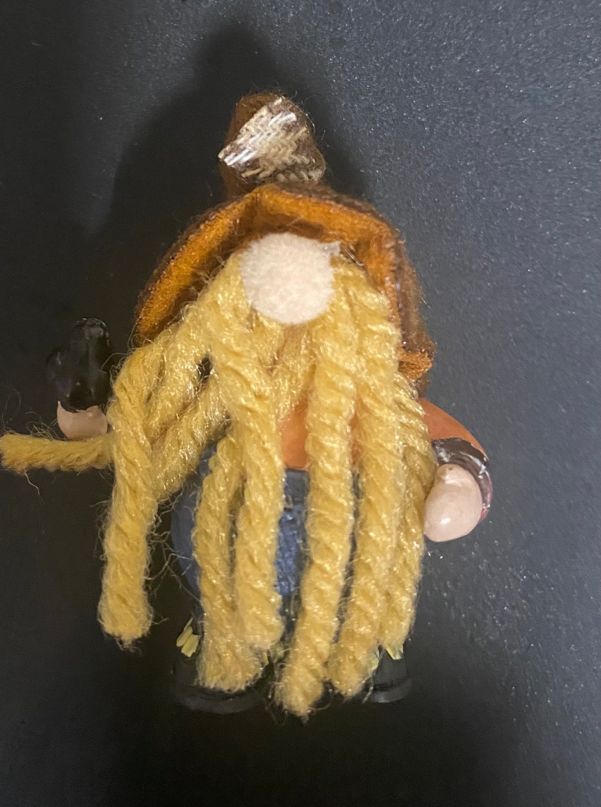 Small knitted gnome figure on a dark background