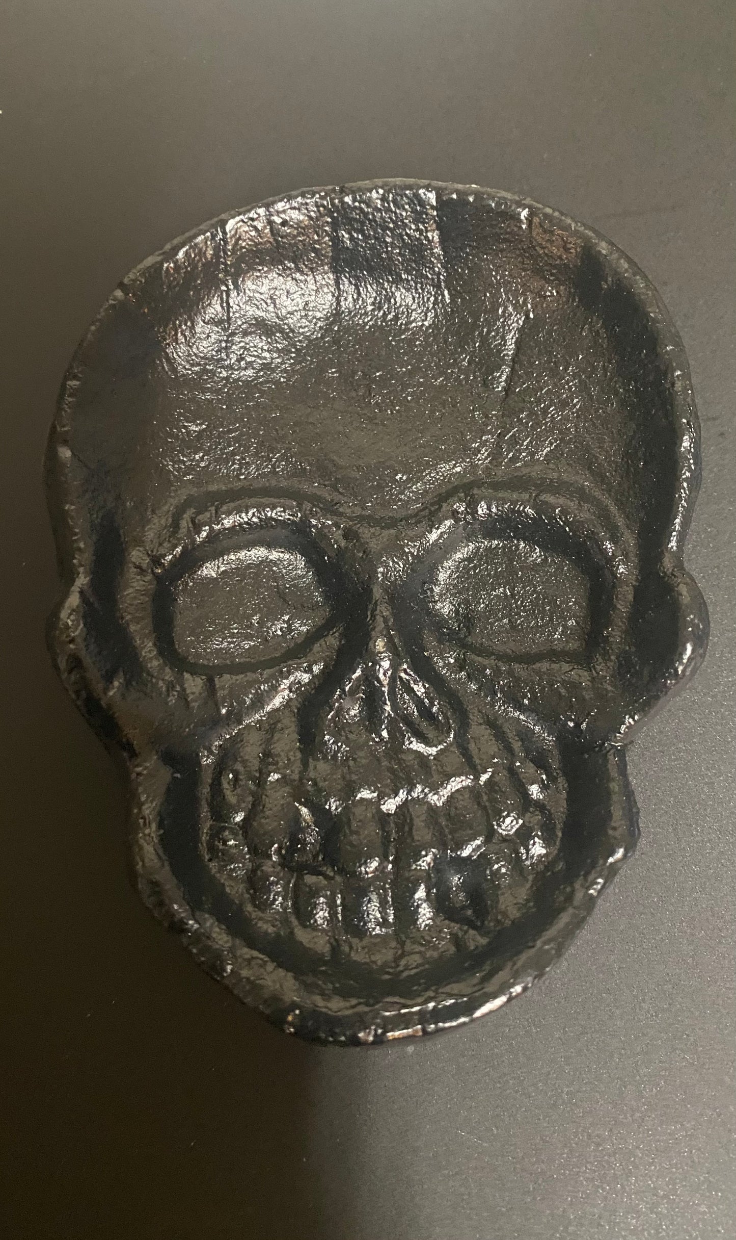 Metallic skull-shaped object on a dark background
