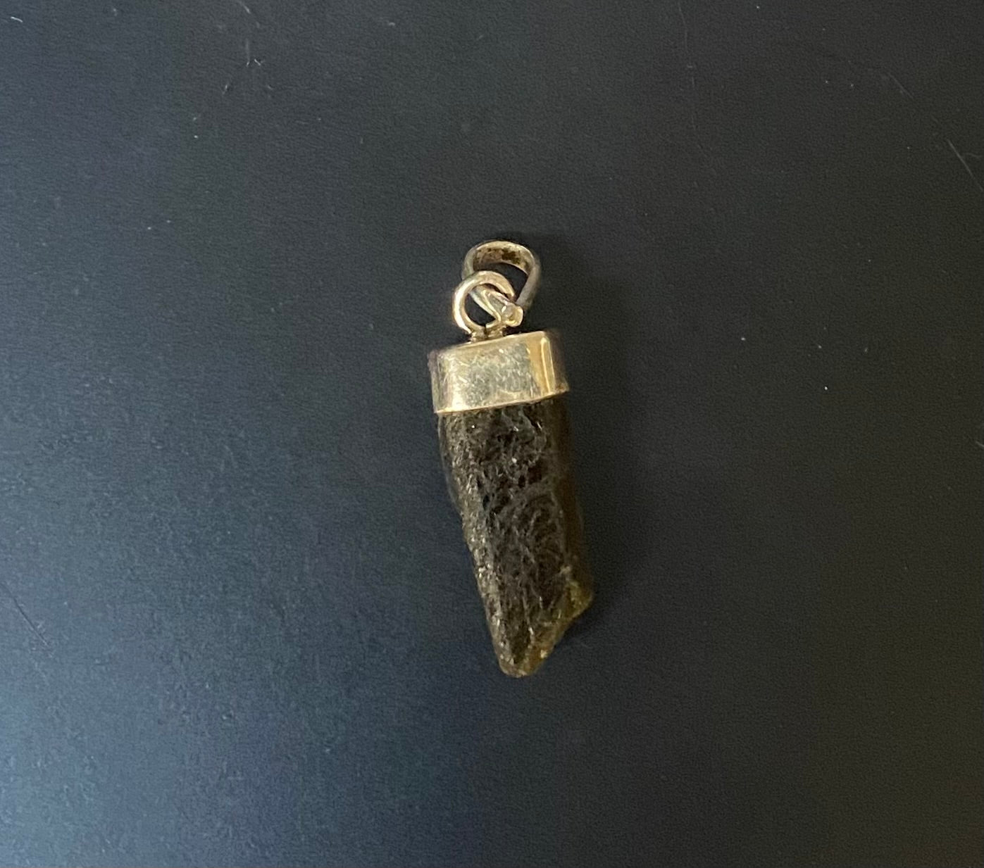 Sterling Silver pendant with a textured design on a black background