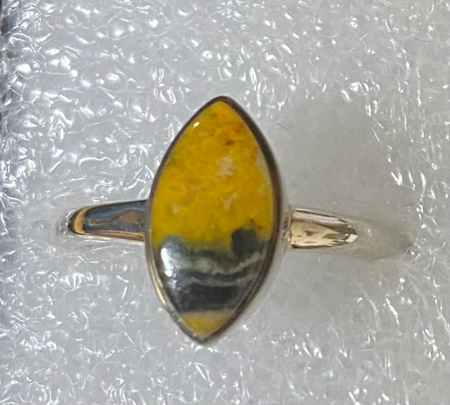 Ring with a yellow and black oval stone on a clear background