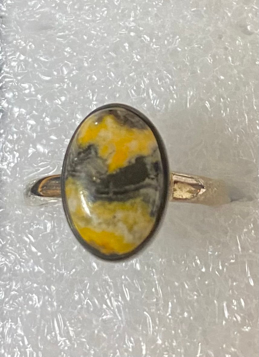 Ring with a yellow and black stone on a white background