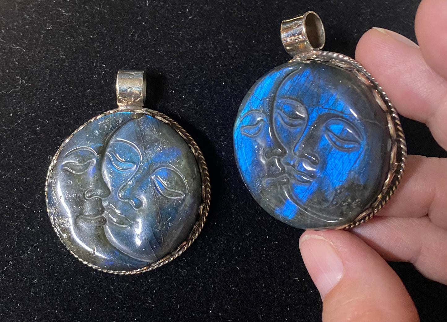 Two face-shaped pendants, one glowing blue, on a dark background.