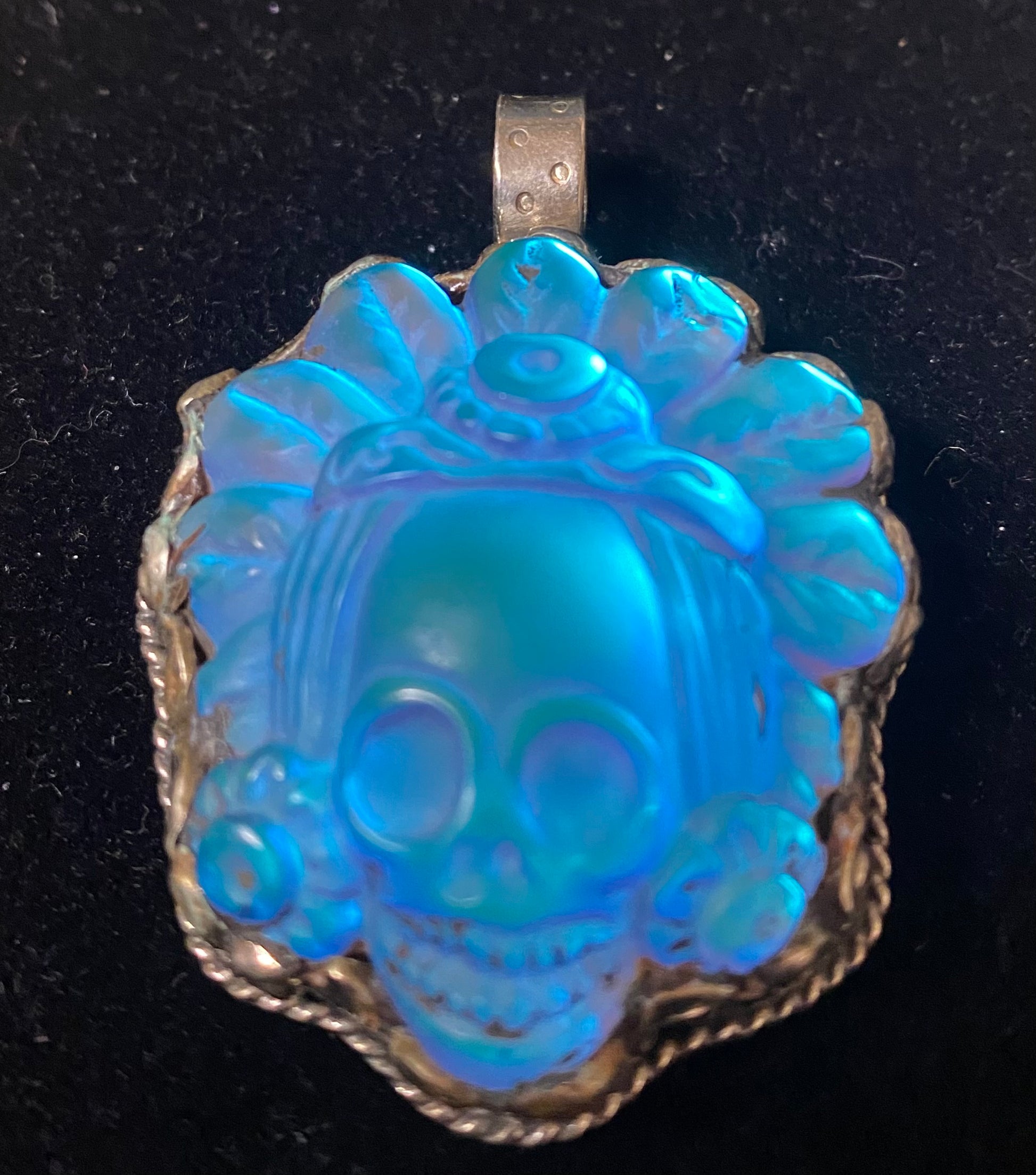 Blue aqua aura quartz skull pendant on a black background