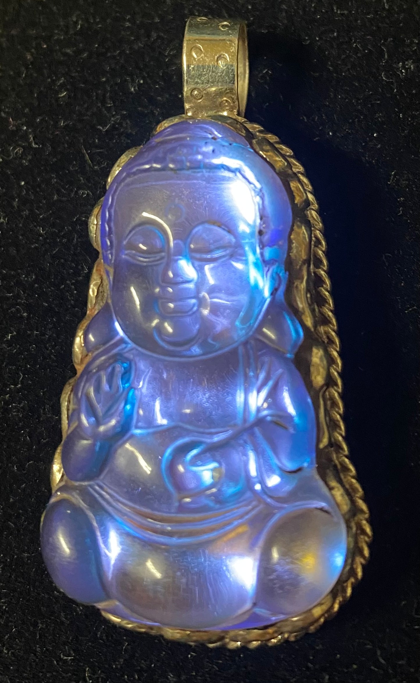 Blue glass Buddha pendant with Sterling Silver frame on a black background