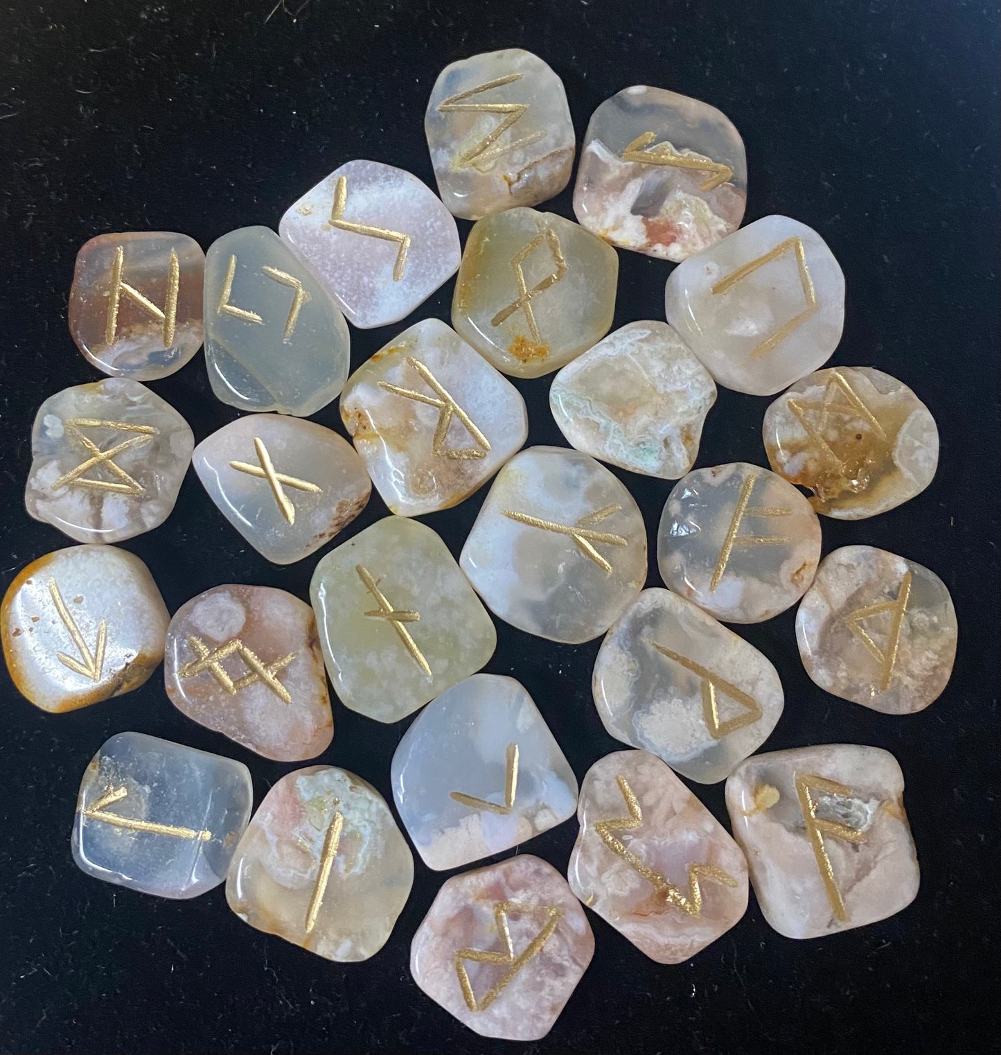 Set of stone runes with gold inscriptions on a dark background
