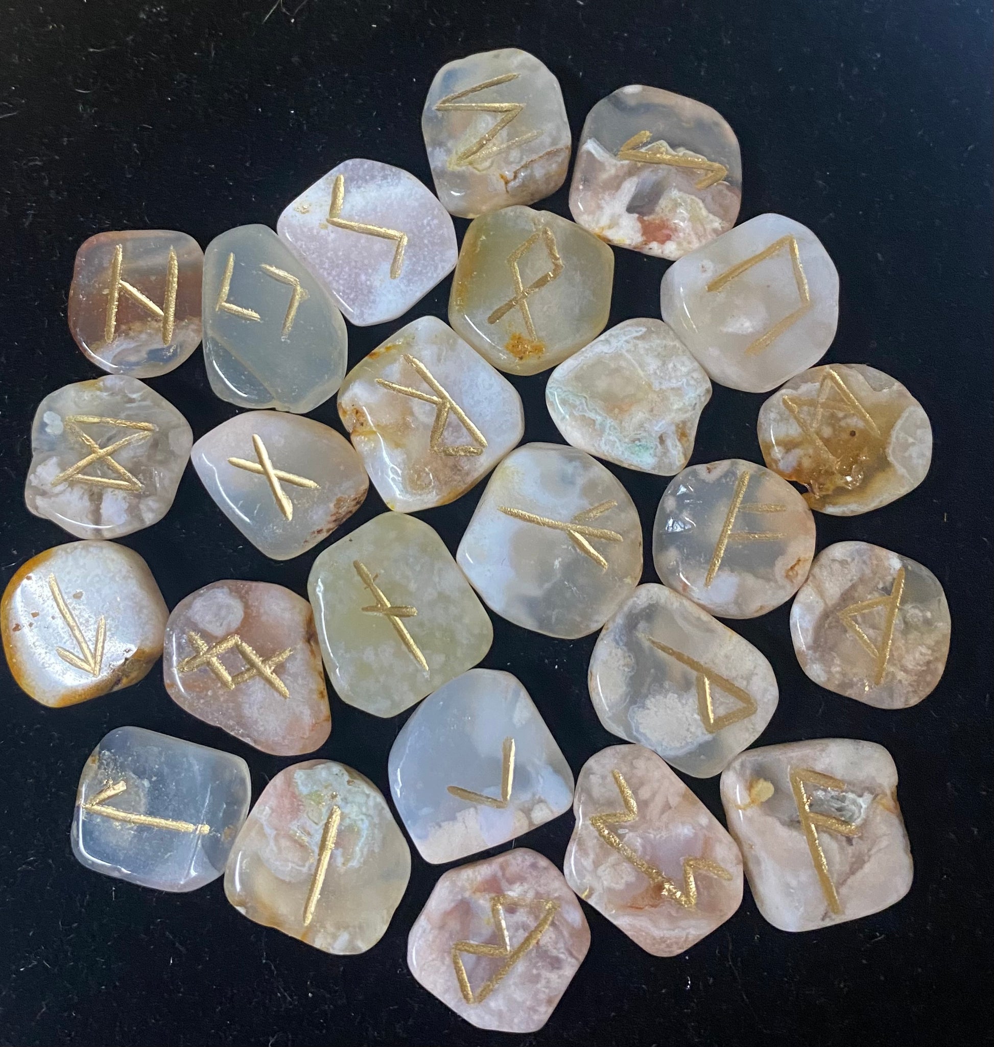 Set of stone runes with gold inscriptions on a dark background