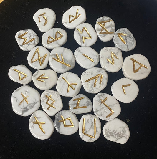 Rune Set Howlite stones with gold runes on a black background