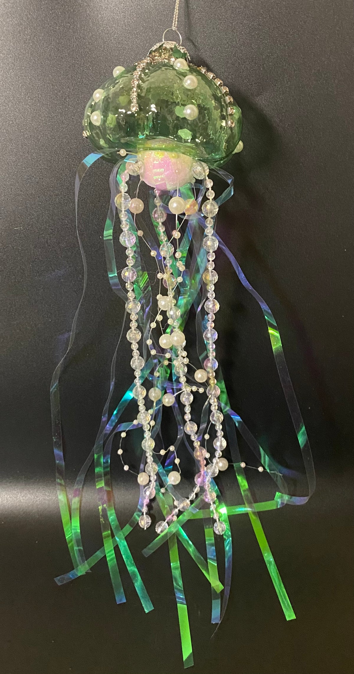 Decorative jellyfish ornament with beads and ribbons on a black background