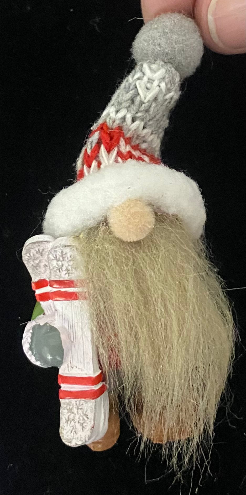 Decorative gnome charm with a red and white hat on a black background