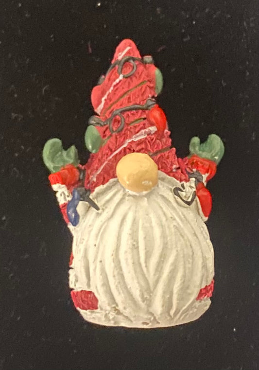 Decorative gnome figurine with red hat and white beard on a black background